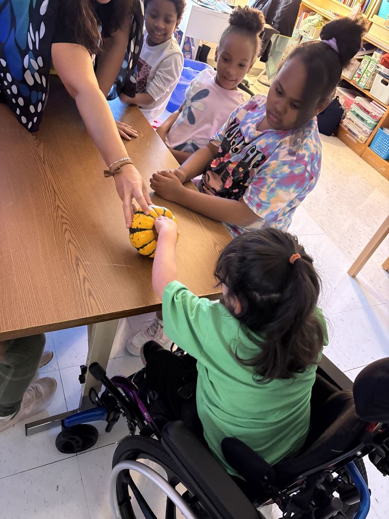 Mrs. Yohe lets student feel inside the pumpkin