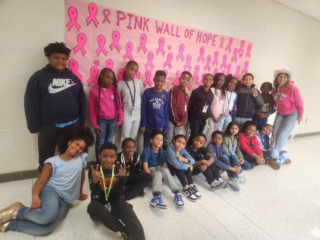 students in front of pink wall of hope