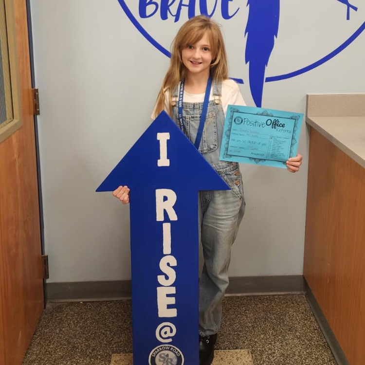 student with I RISE sign 
