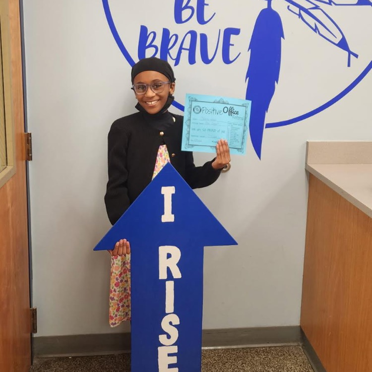 student with I RISE sign