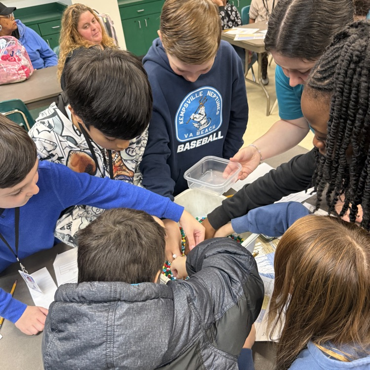 students around learning lab table getting a bucket with beads 