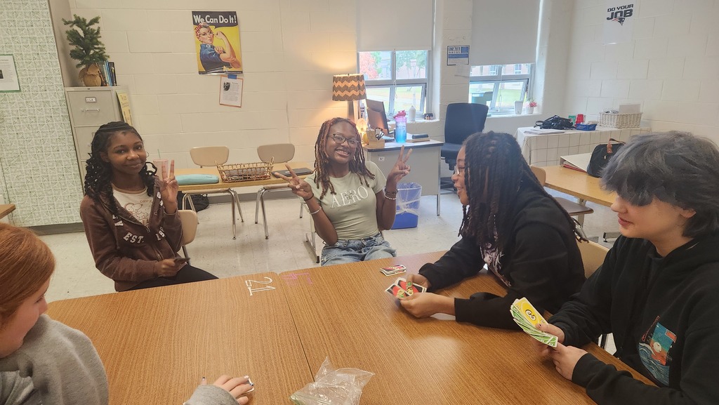 Students enjoying games in the game club. They have uno cards.