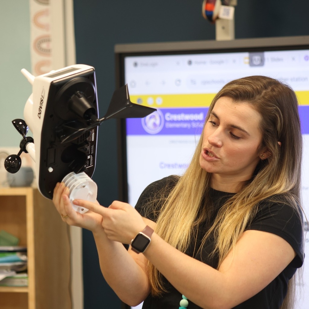 Teacher showing parts of a weather station.