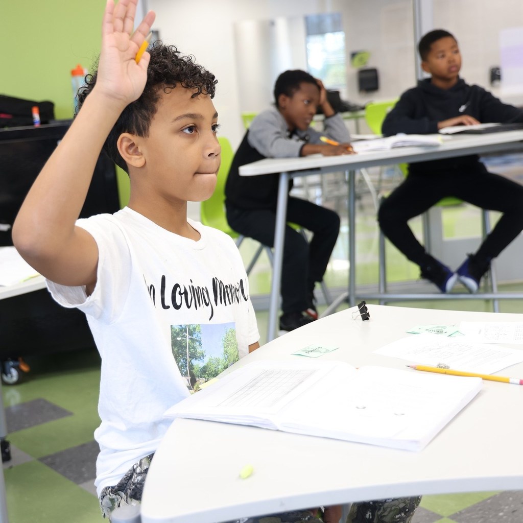 Student raising hand in class.