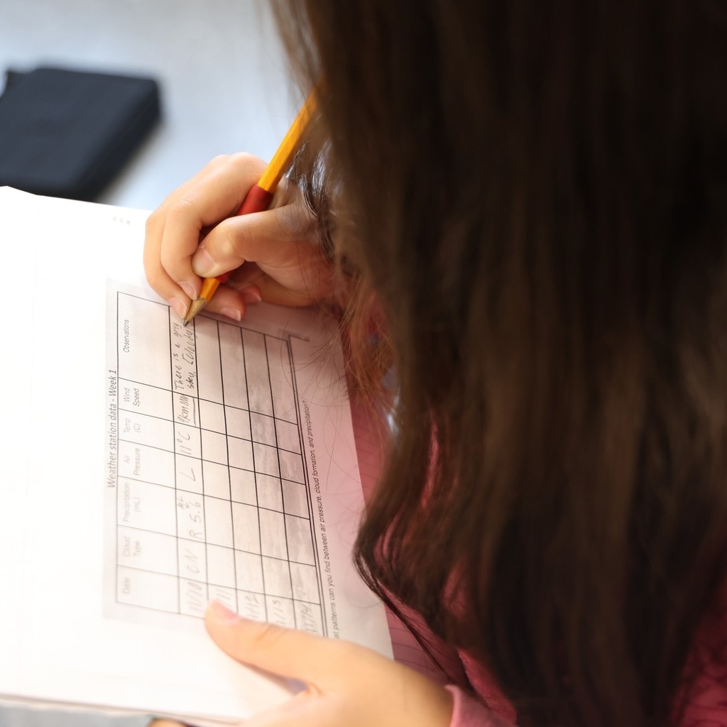 Student writing data on a graph.