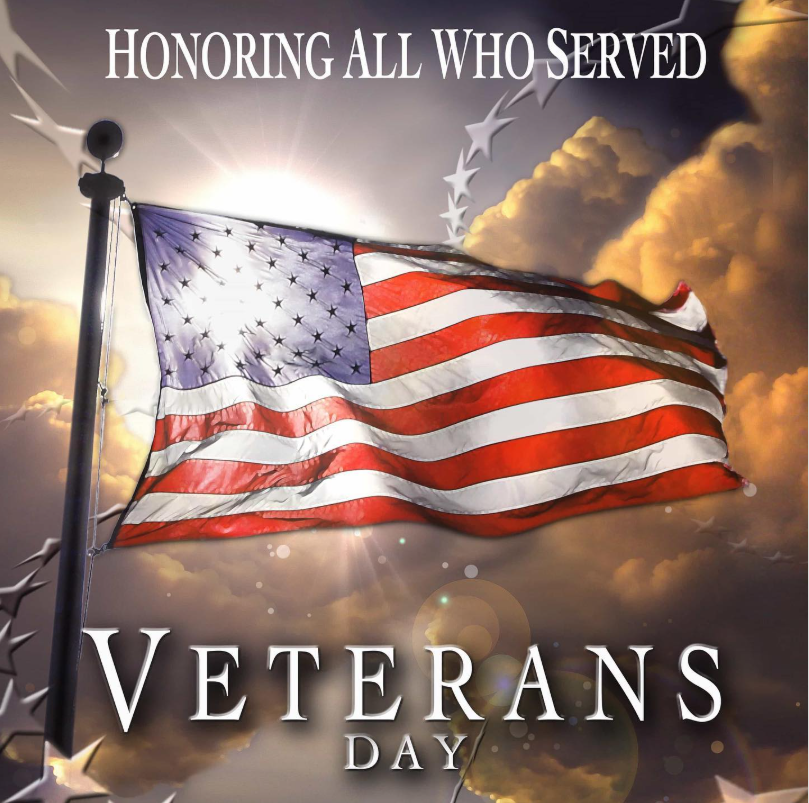 A patriotic graphic for Veterans Day. An American flag waves on a flagpole in front of a bright, cloudy sky as the sun shines from behind it. Text at the top reads, "Honoring All Who Served." Text at the bottom reads, "Veterans Day."