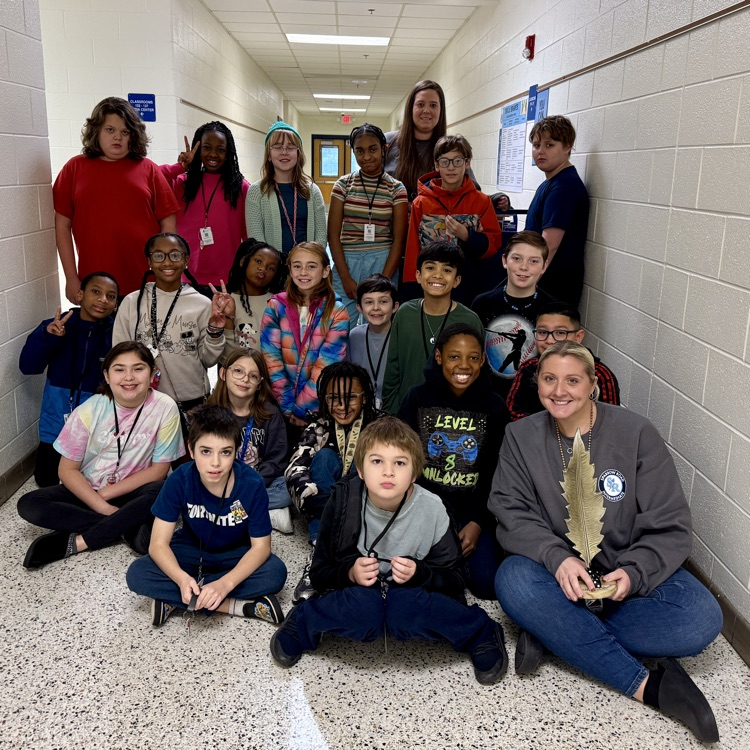 Ms Warner and Mrs Brittingham’s class with the feather of honor statue in the hallway