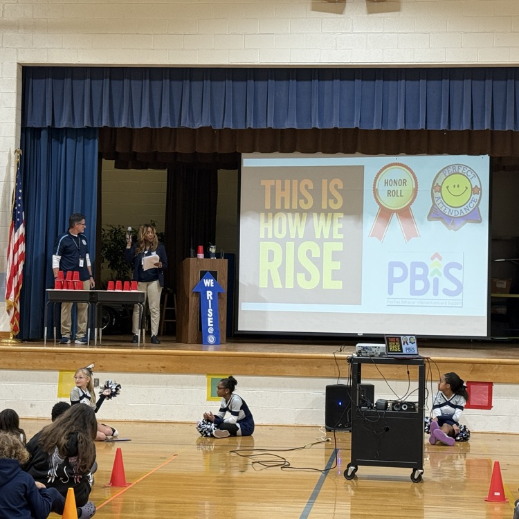 admin on stage announcing honor roll and perfect attendance 