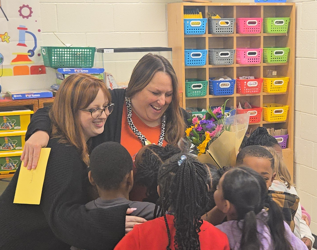 teacher hugging her daughter and students