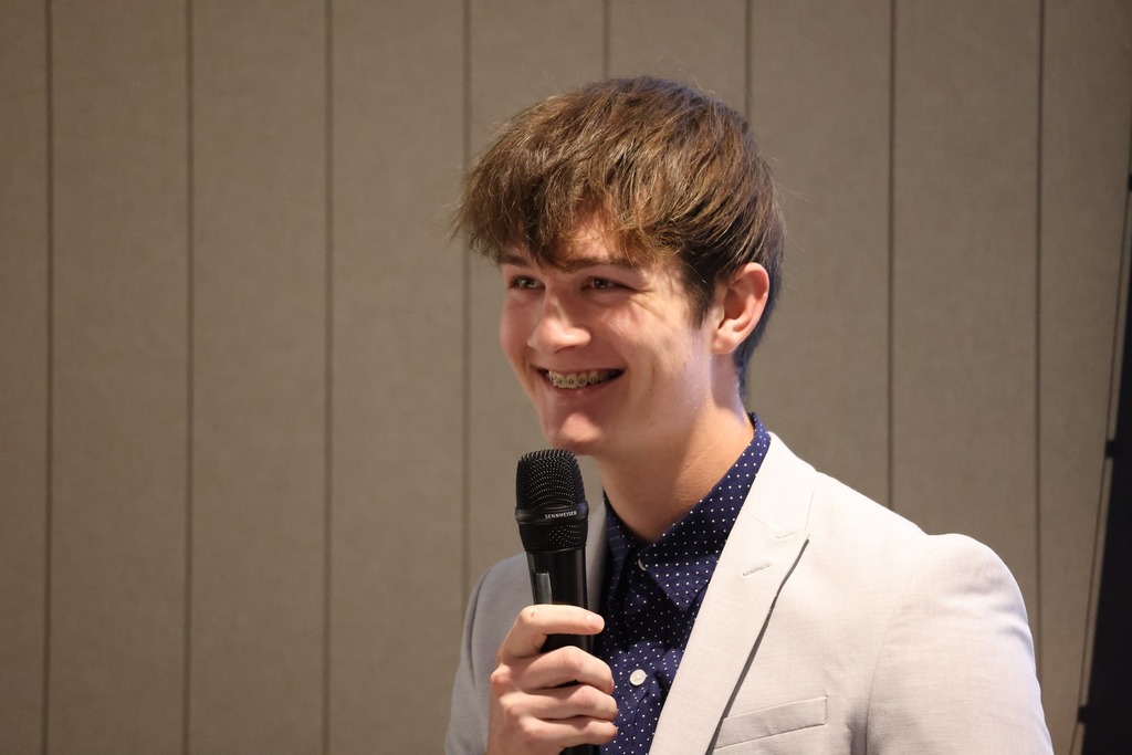 Student speaking and smiling in front of the delegation.