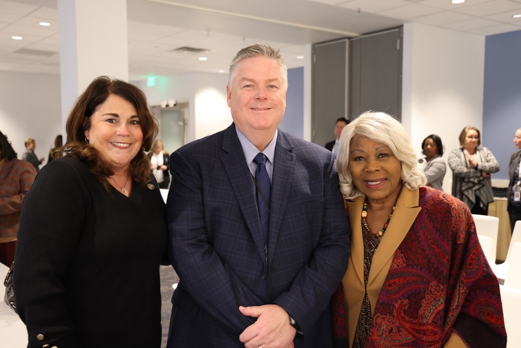 Dr. Cotton smiling with two delegates.