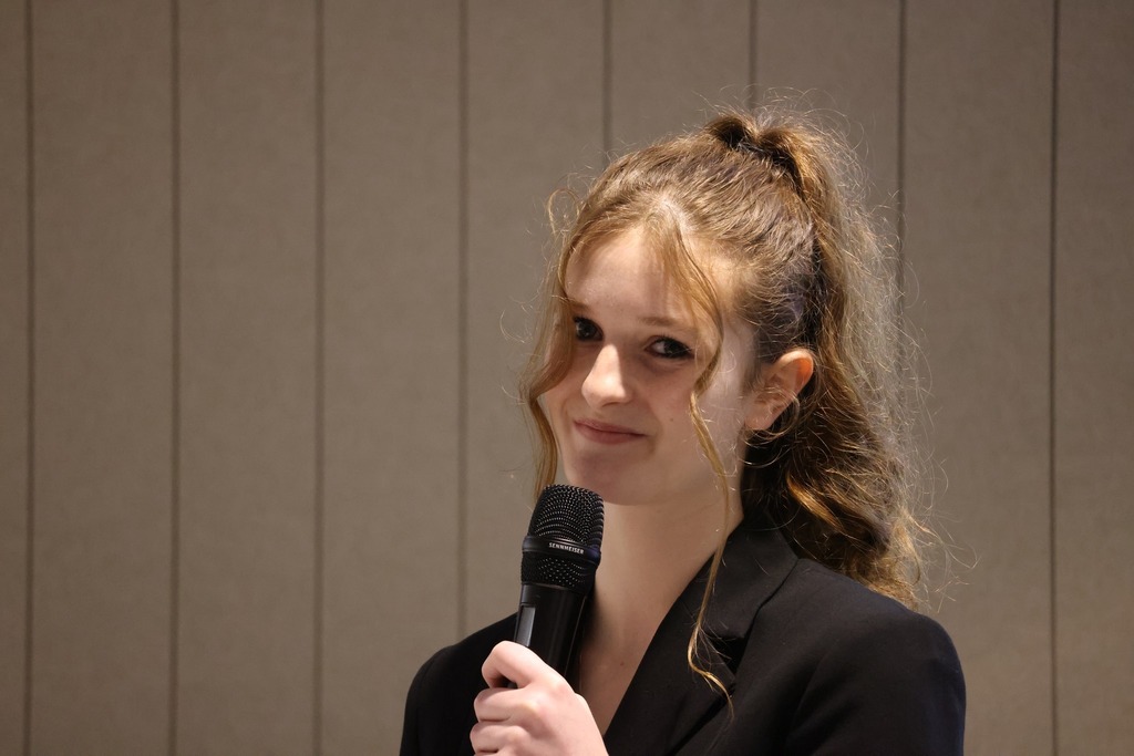 Student speaking and smiling in front of the delegation.
