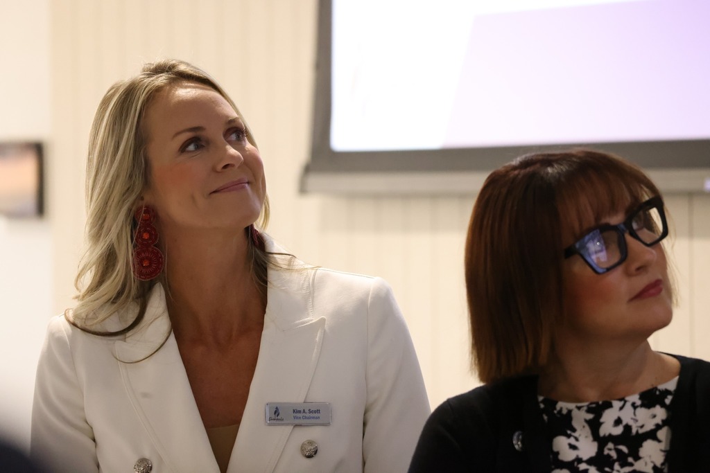 Board members smiling and looking at a presentation.
