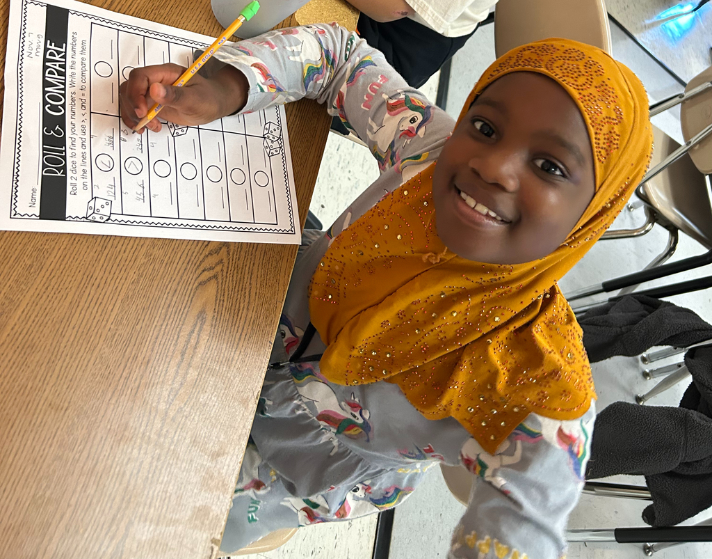 student plays roll and compare to practice comparing numbers