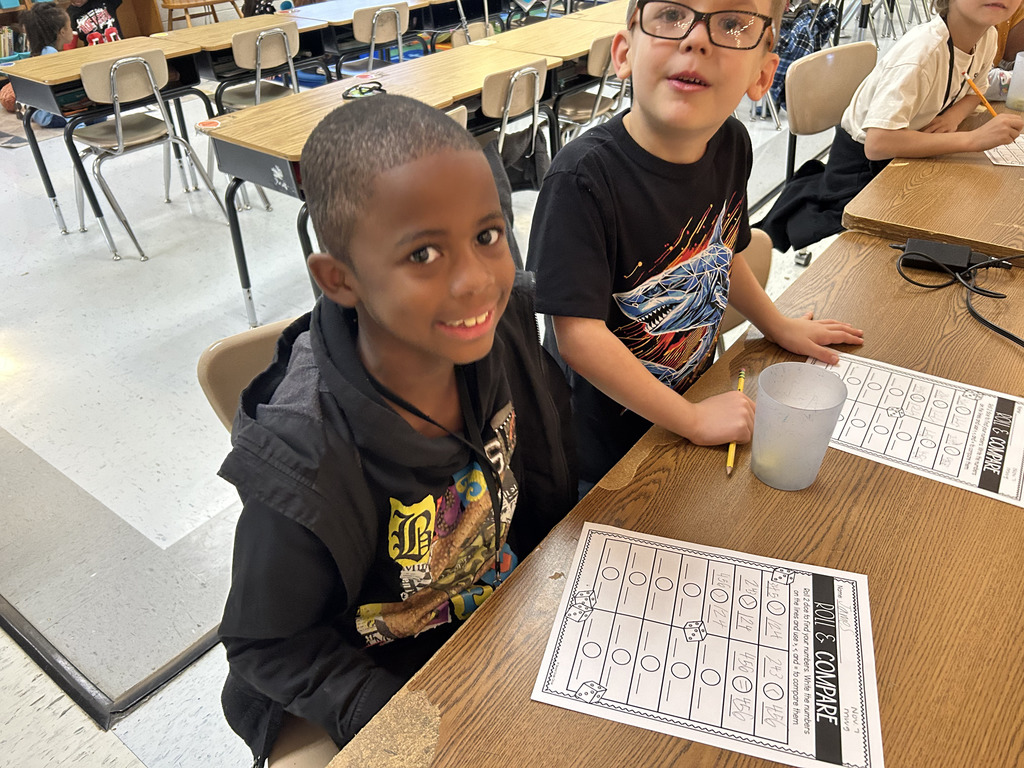 students play roll and compare to practice comparing numbers