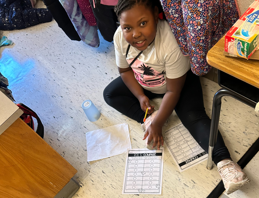 student plays roll and compare to practice comparing numbers