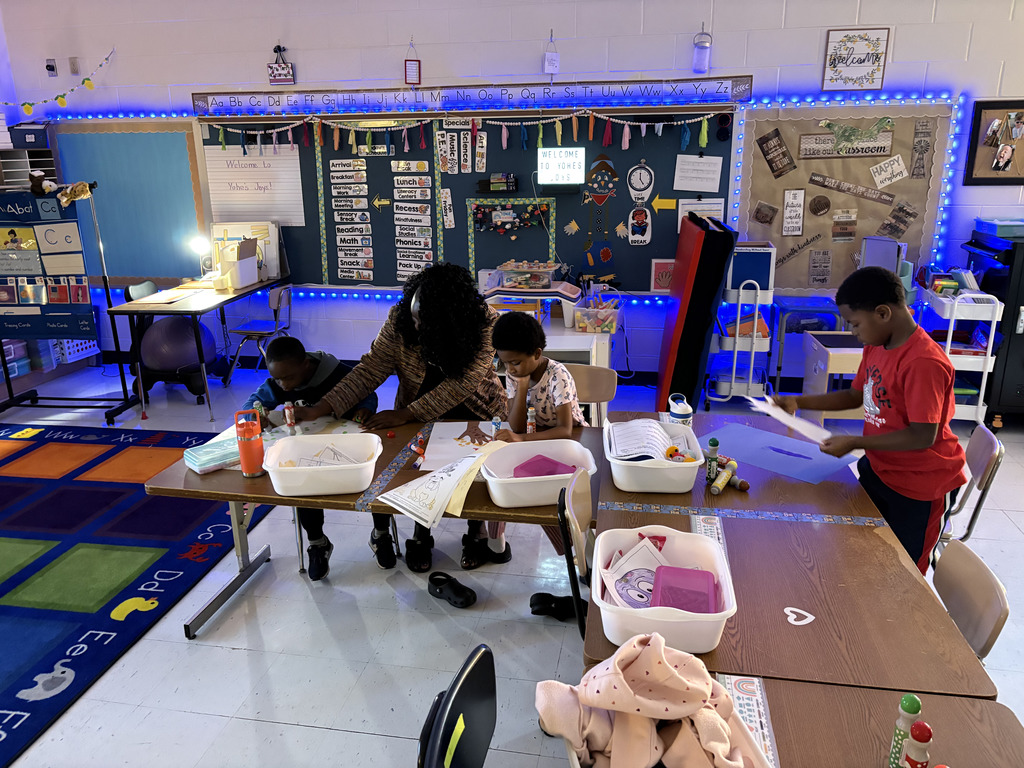 students creating colorful fall trees with hand trunks and bingo marker leaves
