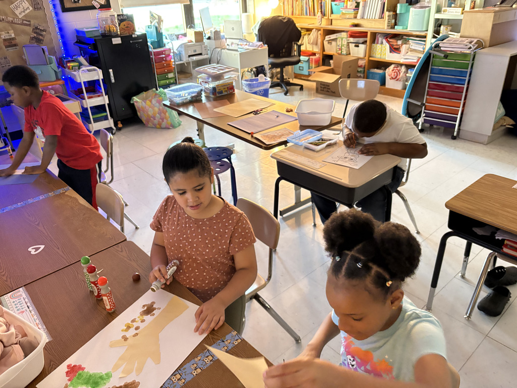 students creating colorful fall trees with hand trunks and bingo marker leaves