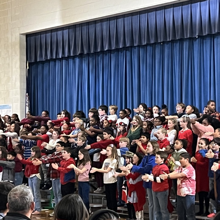 students on bleachers with hands out
