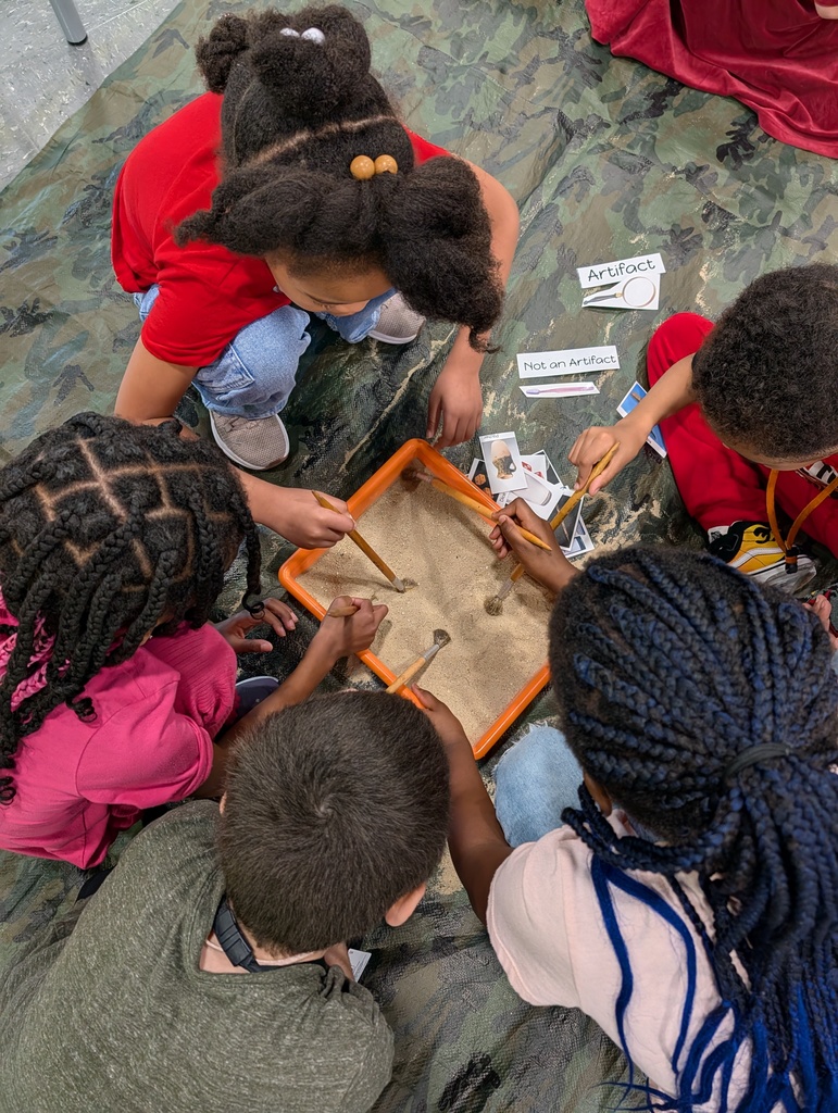 students digging through sand