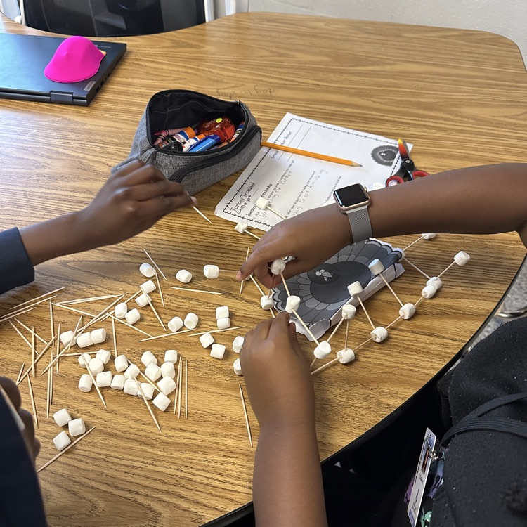 close up of hands working with toothpicks and marshmallows for the turkey challenge