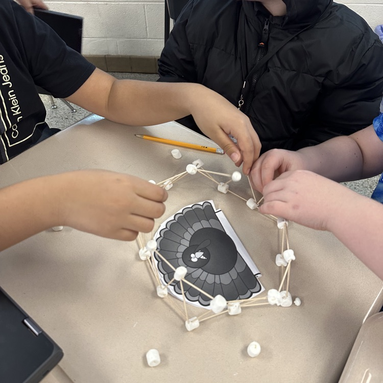 close up of hands working with toothpicks and marshmallows for the turkey challenge