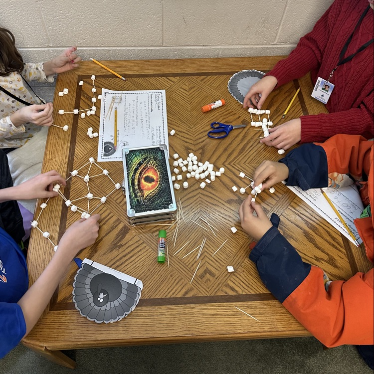 close up of hands working with toothpicks and marshmallows for the turkey 