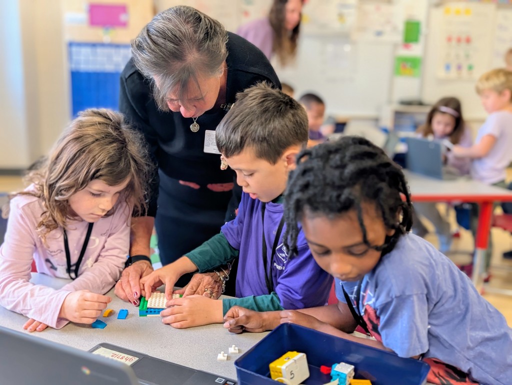 Kindergarten students building a Lego car to measure and then measure the distance it will travel at varying speeds.