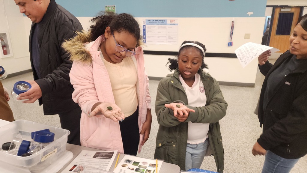 Students holding snails at the Elizabeth River Project Table
