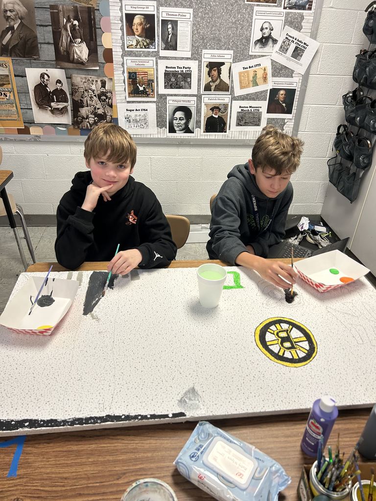 two boys painting tiles for the ceiling