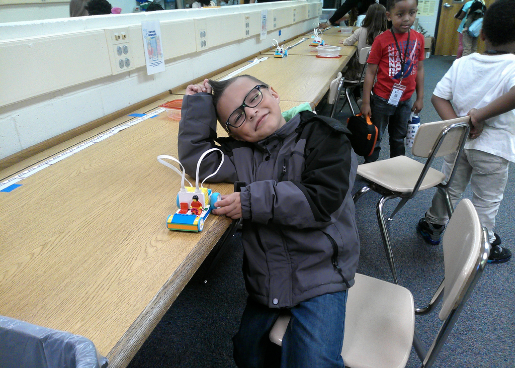 students poses with his Lego taxi, built to investigate pushes and pulls