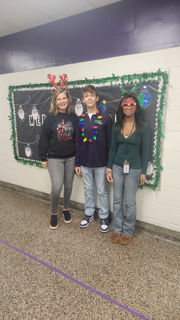 A teacher and two students wearing their festive holiday outfits!