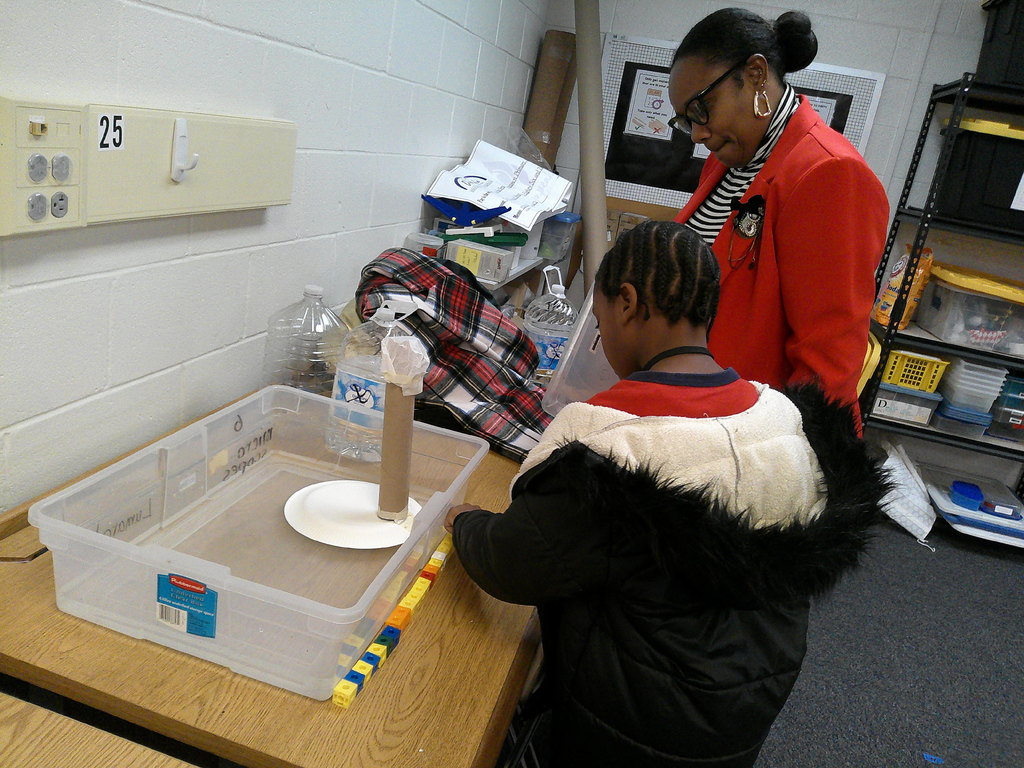 first grade student tests boats for recycle regatta