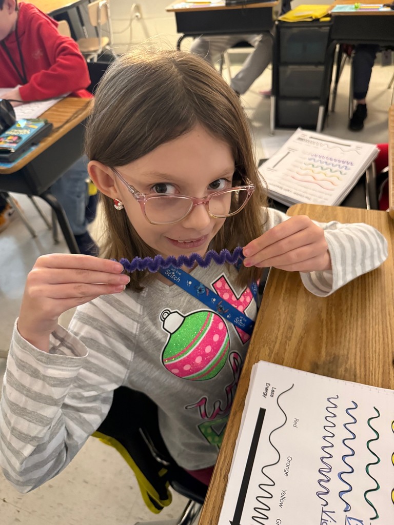 Student holding up violet pipe cleaner