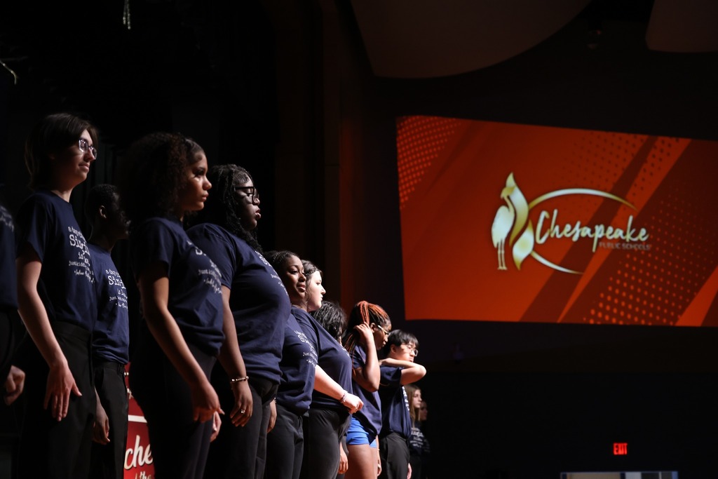 group of students standing in front of cps board