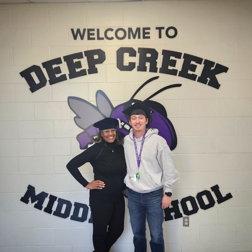 Mr. Mobley and Dr. Davenport in front of our DEEP CREEK MIDDLE SCHOOL sign with their Graduation Caps!