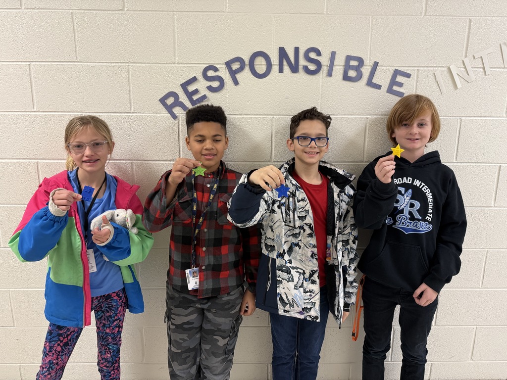4 students holding up brag tags