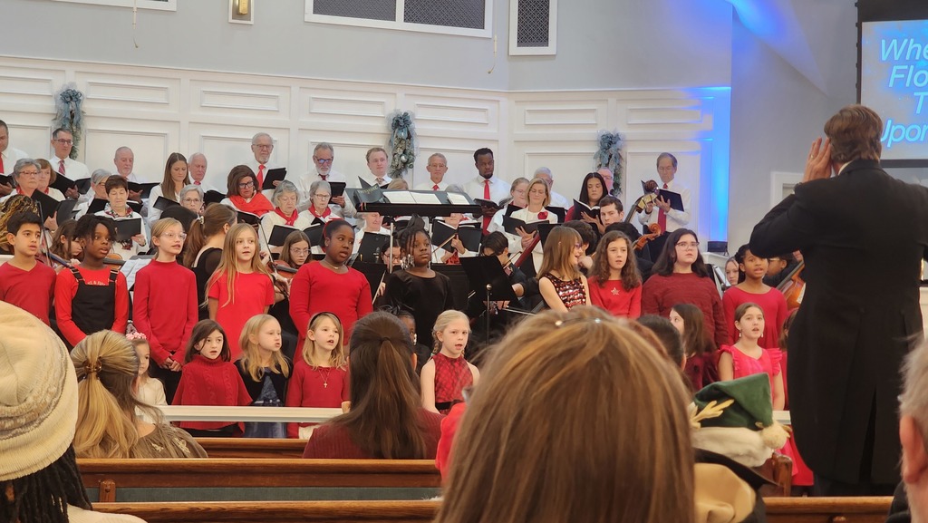 Students and other adult singers in the choir performing 