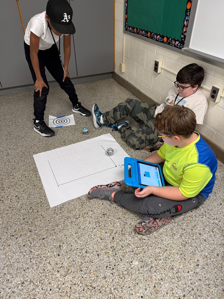 Students around a paper trying to code their Sphero.
