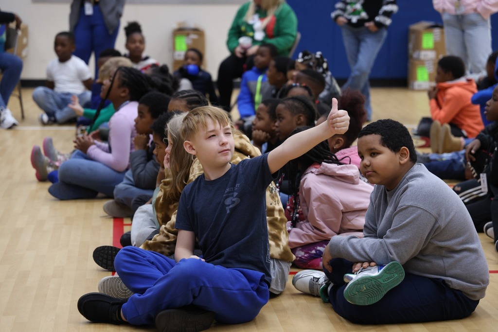 boy giving thumbs up and sitting on floor