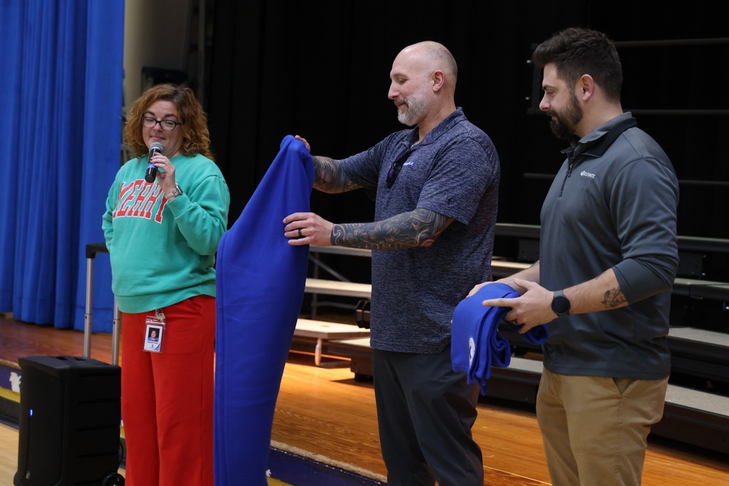 man presenting blankets and principal watching