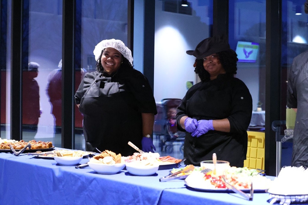 two OSHS culinary students serving