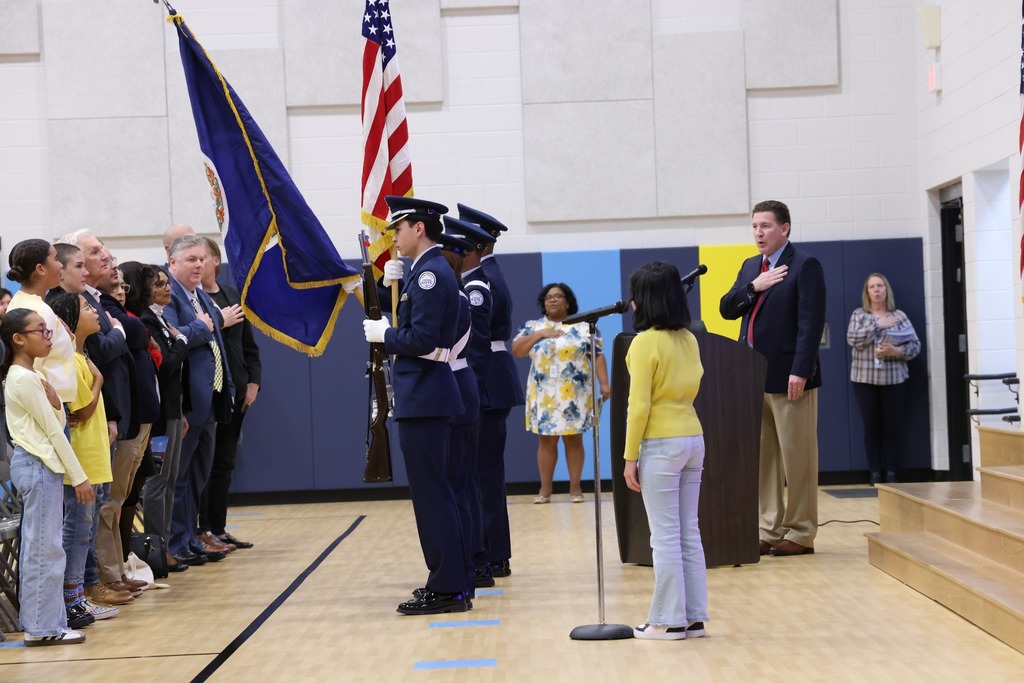 ROTC with flags and Student delivering the pledge in CWE gym