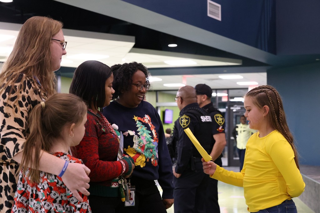 Student reading to group of parents and students