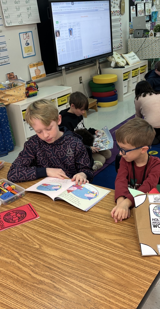 Mrs. May's reading buddies reading Christmas stories to their Kindergarten buddies in Mrs. Escobedo's class