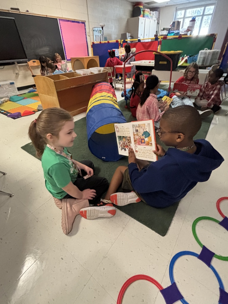 Mrs. May's reading buddies reading Christmas stories to their Kindergarten buddies in Mrs. Escobedo's class
