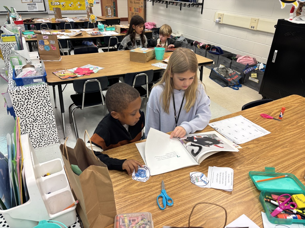 Mrs. May's reading buddies reading Christmas stories to their Kindergarten buddies in Mrs. Escobedo's class
