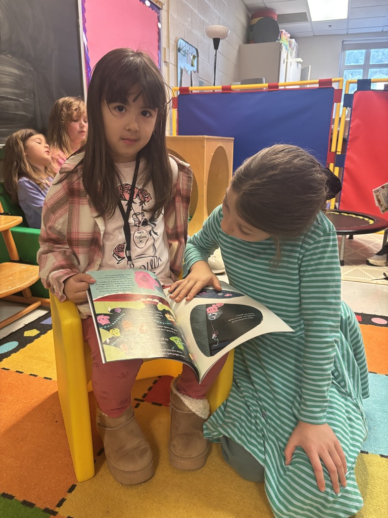 Mrs. May's reading buddies reading Christmas stories to their Kindergarten buddies in Mrs. Escobedo's class