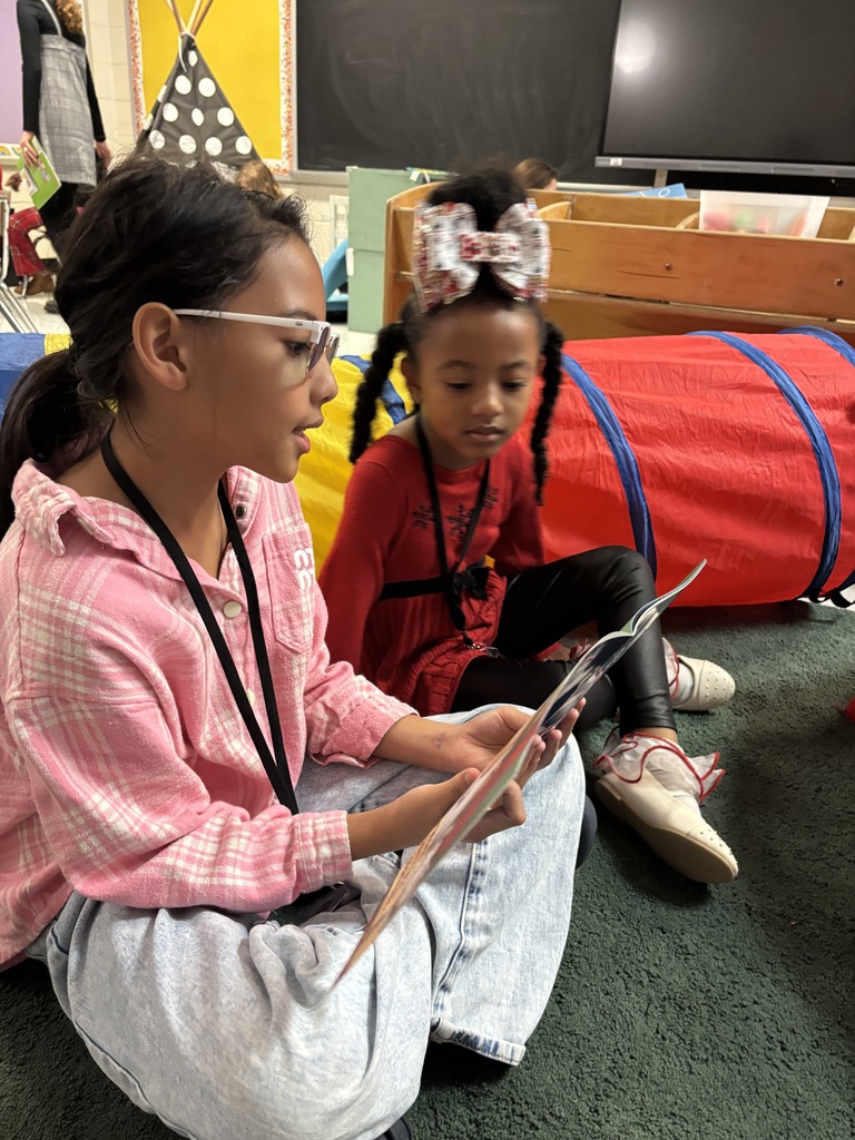 Mrs. May's reading buddies reading Christmas stories to their Kindergarten buddies in Mrs. Escobedo's class