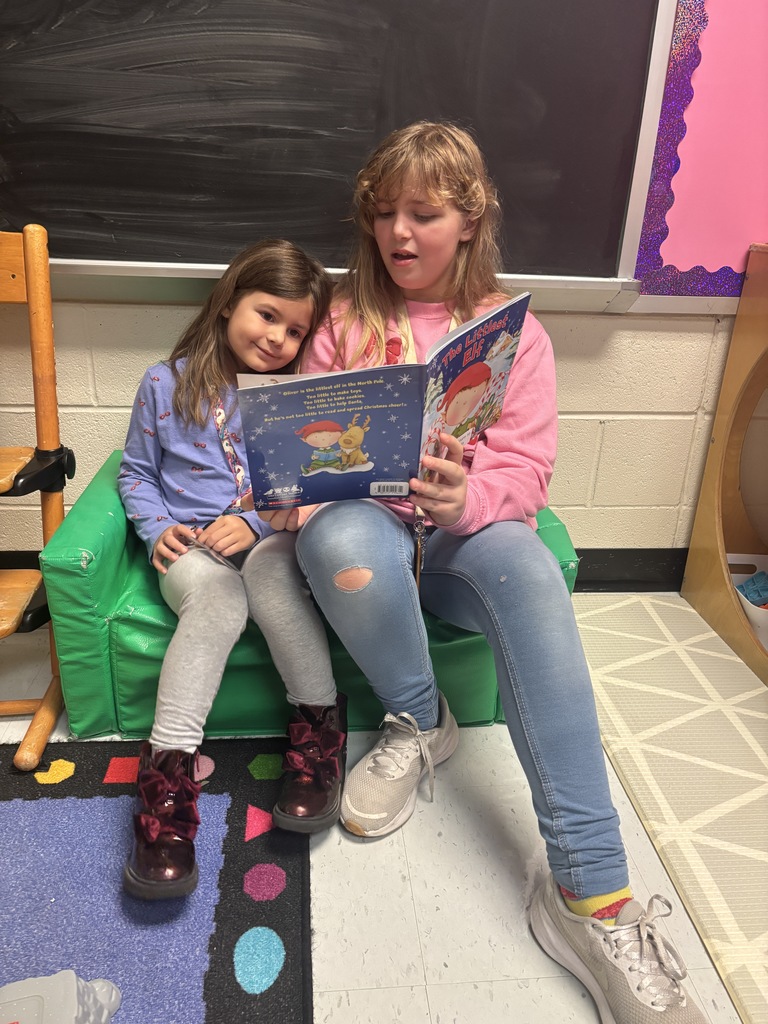 Mrs. May's reading buddies reading Christmas stories to their Kindergarten buddies in Mrs. Escobedo's class